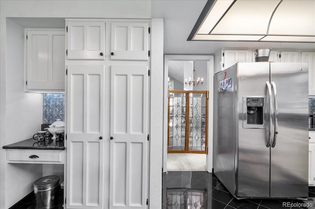 kitchen featuring white cabinetry, dark stone countertops, a notable chandelier, and stainless steel refrigerator with ice dispenser