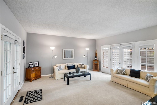 living room with a textured ceiling, french doors, and light colored carpet