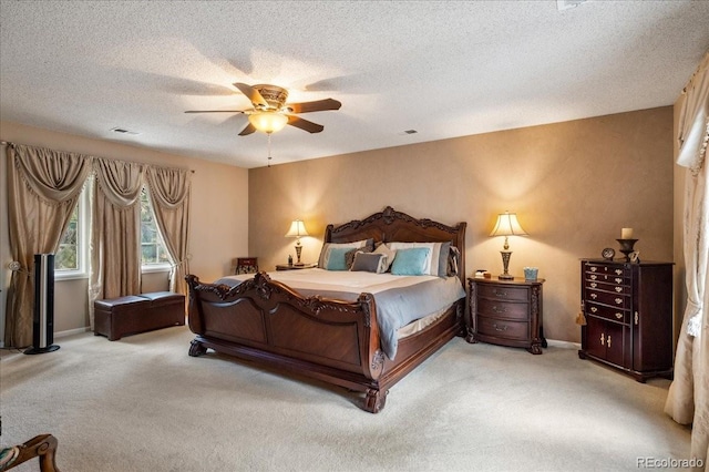 bedroom featuring ceiling fan, light carpet, and a textured ceiling