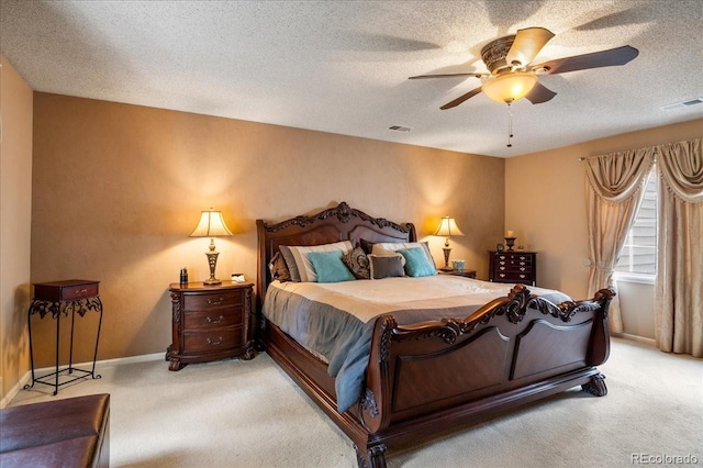 carpeted bedroom featuring ceiling fan and a textured ceiling