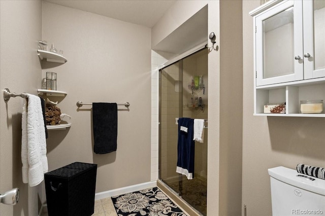 bathroom featuring tile patterned floors, a shower with shower door, and toilet