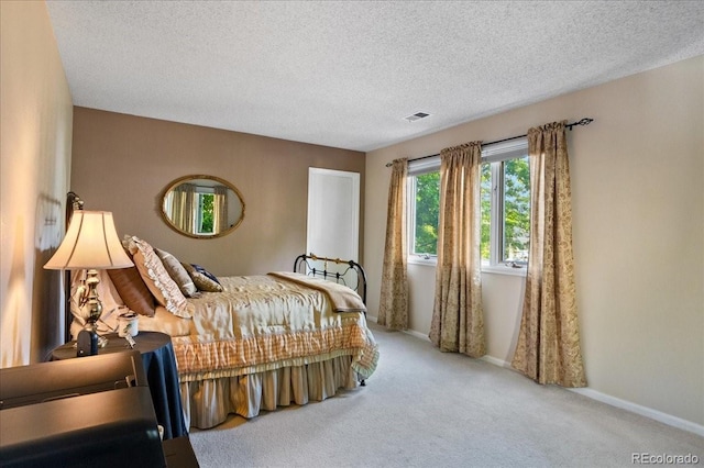 bedroom with carpet and a textured ceiling