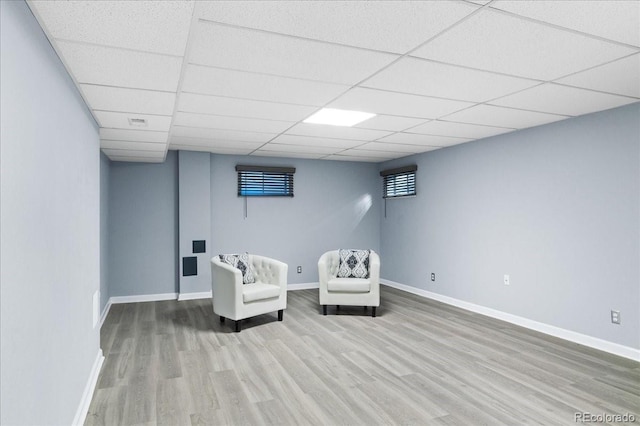 living area with hardwood / wood-style flooring and a drop ceiling