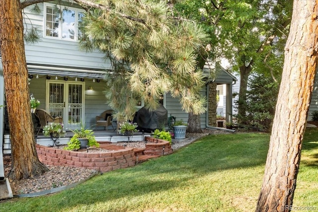 exterior space featuring a yard and french doors