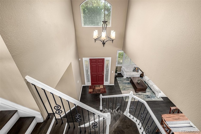 8410 S Oak St, Littleton, CO 80127 - foyer featuring a chandelier, wood finished floors, a textured wall, a towering ceiling, and stairs