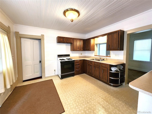 kitchen with light tile patterned flooring, sink, white gas range, and ornamental molding