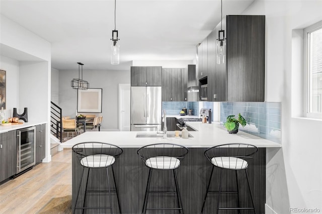 2435 S High St, Denver, CO 80210 - kitchen with stainless steel appliances, wine cooler, modern cabinets, tasteful backsplash, and light countertops