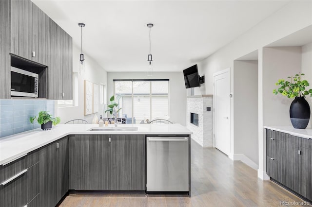 2435 S High St, Denver, CO 80210 - kitchen featuring stainless steel appliances, gray cabinets, a peninsula, light countertops, and light wood-style floors
