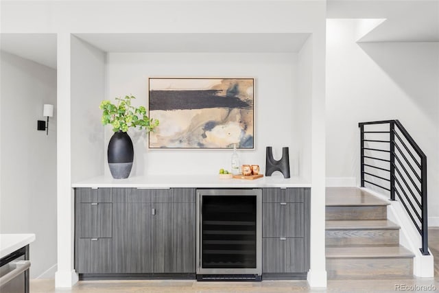 2435 S High St, Denver, CO 80210 - indoor dry bar with wine cooler, stairs, light wood-style floors, and baseboards