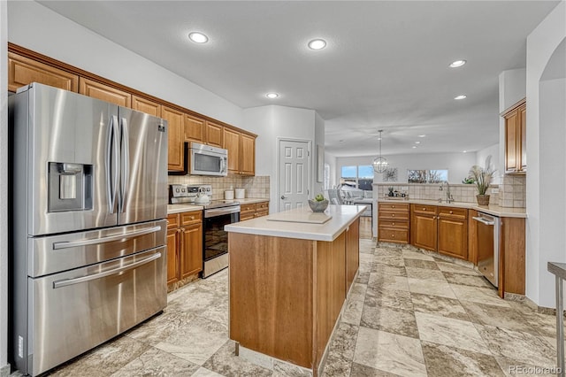 kitchen featuring kitchen peninsula, tasteful backsplash, stainless steel appliances, decorative light fixtures, and a kitchen island