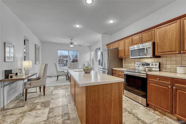 kitchen featuring tasteful backsplash, stainless steel appliances, a kitchen island, and ceiling fan