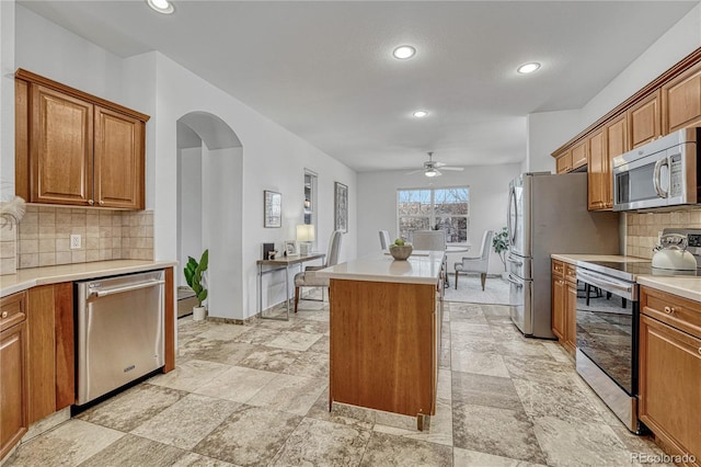 kitchen featuring ceiling fan, appliances with stainless steel finishes, and tasteful backsplash