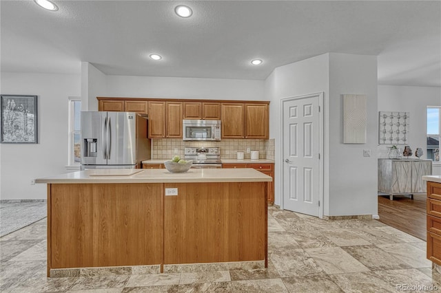 kitchen with tasteful backsplash, a kitchen island, and appliances with stainless steel finishes