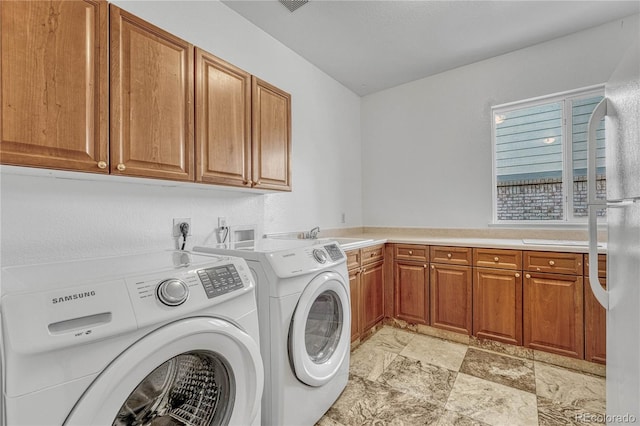 washroom featuring cabinets, separate washer and dryer, and sink