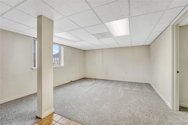 basement with a drop ceiling and light colored carpet