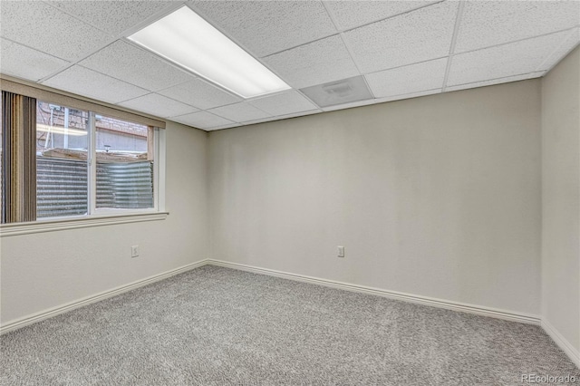 unfurnished room with carpet flooring and a paneled ceiling