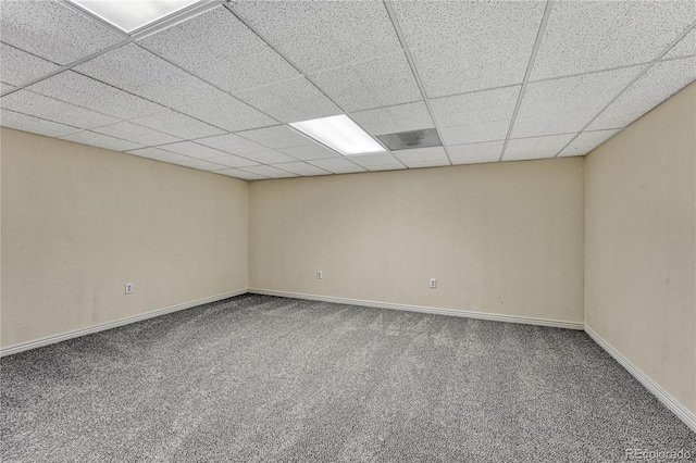 empty room with carpet and a paneled ceiling