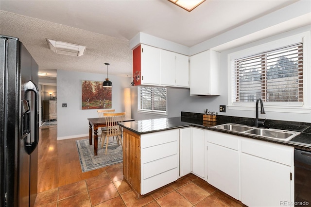 kitchen featuring a wealth of natural light, black appliances, sink, white cabinets, and kitchen peninsula