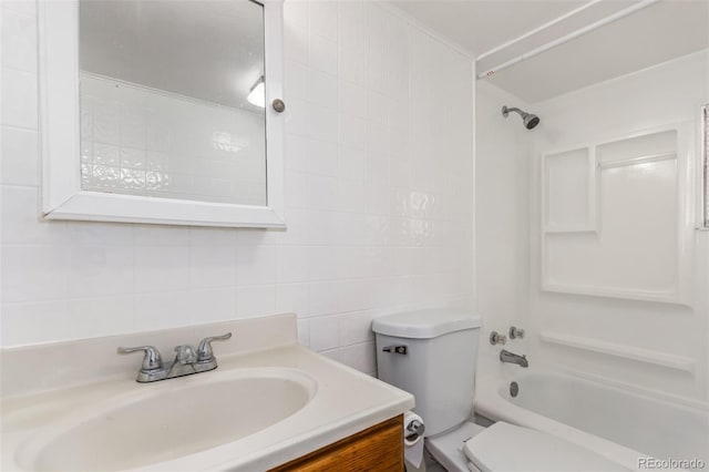 full bathroom featuring shower / bathing tub combination, vanity, toilet, and tile walls