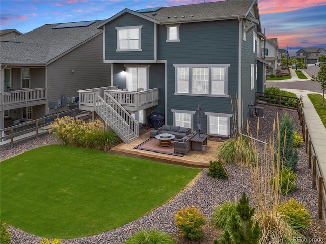 12940 Brier Ct, Firestone, CO 80504 - back of property at dusk with an outdoor living space with a fire pit, a wooden deck, a fenced backyard, and roof with shingles