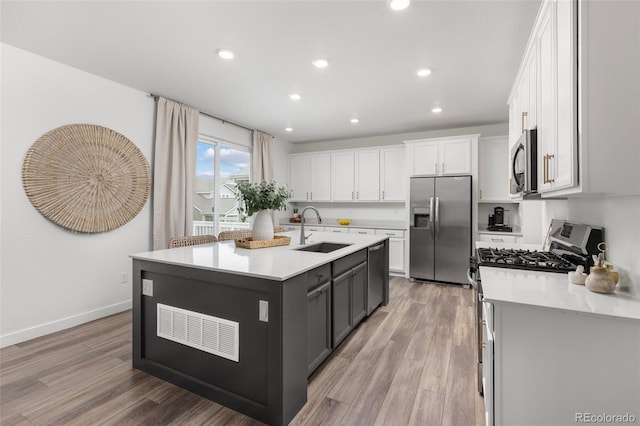 12940 Brier Ct, Firestone, CO 80504 - kitchen featuring appliances with stainless steel finishes, white cabinetry, light countertops, recessed lighting, and light wood-style floors
