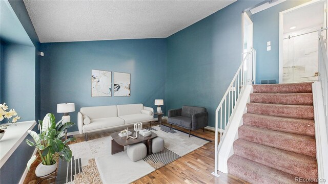 4396 Dearborn St, Denver, CO 80239 - living area with stairs, lofted ceiling, wood finished floors, and a textured ceiling