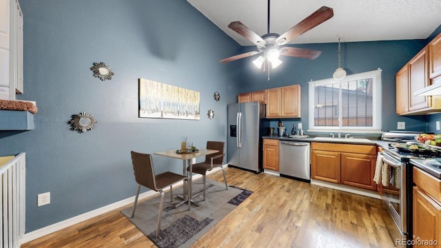 4396 Dearborn St, Denver, CO 80239 - kitchen with appliances with stainless steel finishes, a ceiling fan, light wood finished floors, and vaulted ceiling