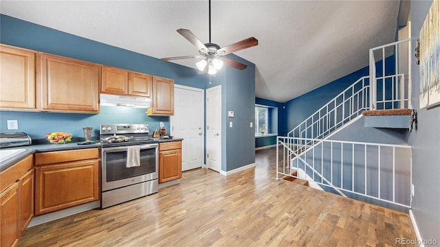 4396 Dearborn St, Denver, CO 80239 - kitchen with stainless steel electric stove, under cabinet range hood, a ceiling fan, vaulted ceiling, and light wood-style floors