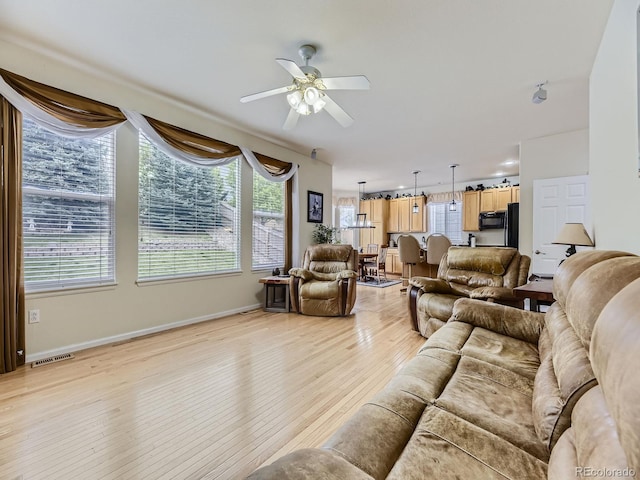 living room featuring ceiling fan and light wood-type flooring