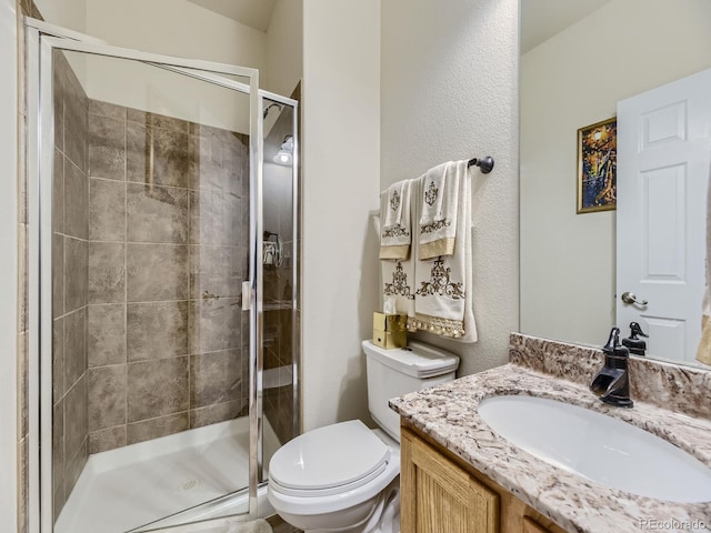 bathroom featuring walk in shower, vanity, and toilet