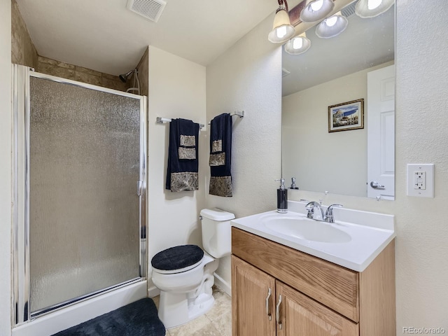 bathroom featuring tile patterned floors, vanity, toilet, and a shower with shower door