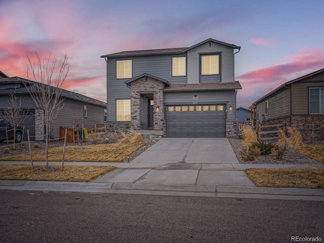 traditional home with driveway, stone siding, a garage, and fence