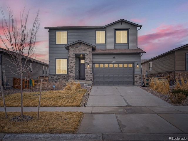 traditional-style house featuring a garage, concrete driveway, and stone siding