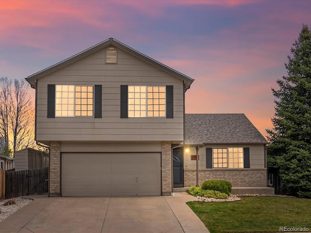 view of front of house with driveway, a front yard, a garage, brick siding, and fence