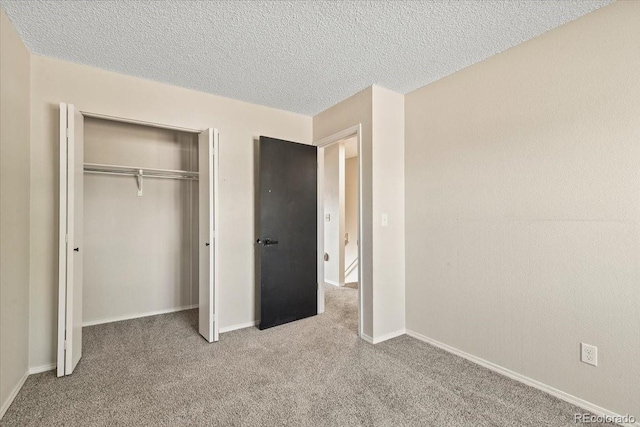 unfurnished bedroom with light carpet, a textured ceiling, and a closet