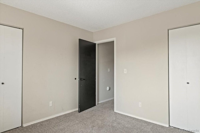 unfurnished bedroom with a textured ceiling and light colored carpet