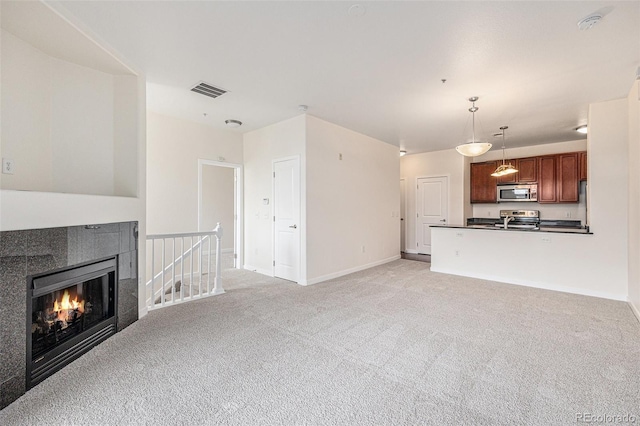 4100 Albion St Unit 617, Denver, CO 80216 - unfurnished living room featuring light colored carpet, baseboards, and a tile fireplace