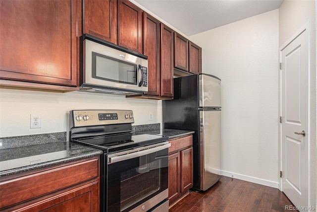 4100 Albion St Unit 617, Denver, CO 80216 - kitchen featuring stainless steel appliances, dark wood finished floors, baseboards, and dark stone countertops