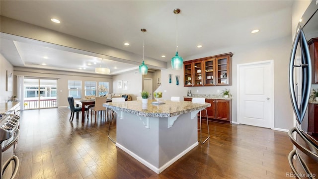 18009 E 47th Pl, Denver, CO 80249 - kitchen with appliances with stainless steel finishes, dark wood-style floors, a kitchen breakfast bar, a center island, and recessed lighting