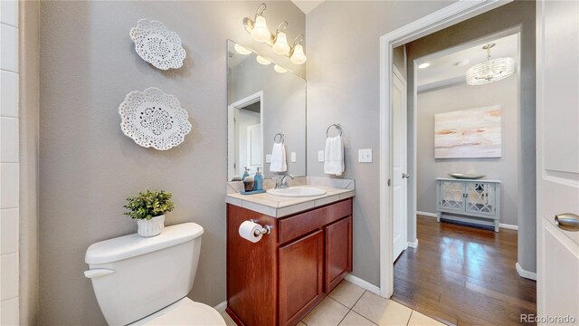 18009 E 47th Pl, Denver, CO 80249 - bathroom with toilet, vanity, wood finished floors, and baseboards
