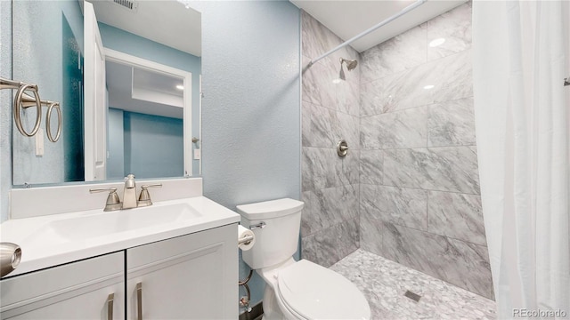 18009 E 47th Pl, Denver, CO 80249 - full bath with toilet, a tile shower, vanity, and a textured wall