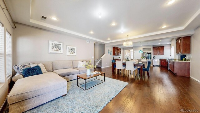 18009 E 47th Pl, Denver, CO 80249 - living room with a tray ceiling, stairs, dark wood-style floors, healthy amount of natural light, and recessed lighting