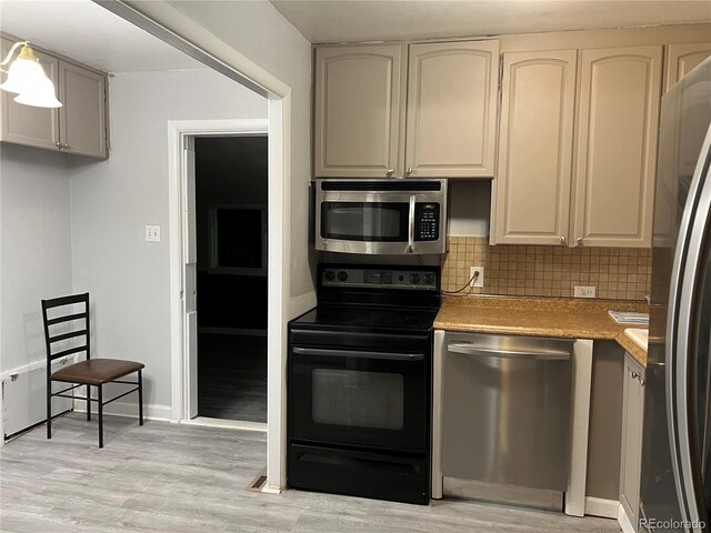 3345 W Evans Ave, Denver, CO 80219 - kitchen featuring stainless steel appliances, decorative backsplash, light wood-style flooring, and light countertops