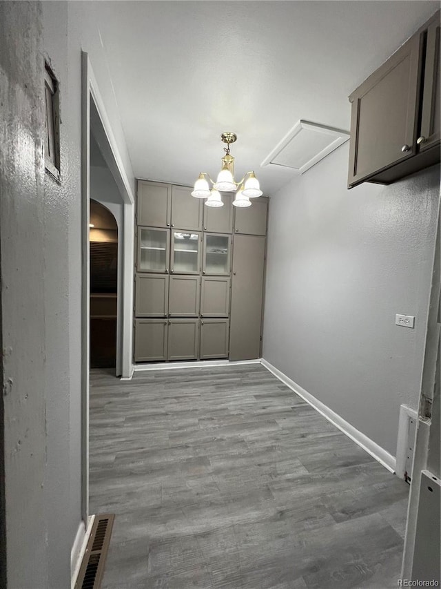 3345 W Evans Ave, Denver, CO 80219 - unfurnished dining area with arched walkways, wood finished floors, and baseboards