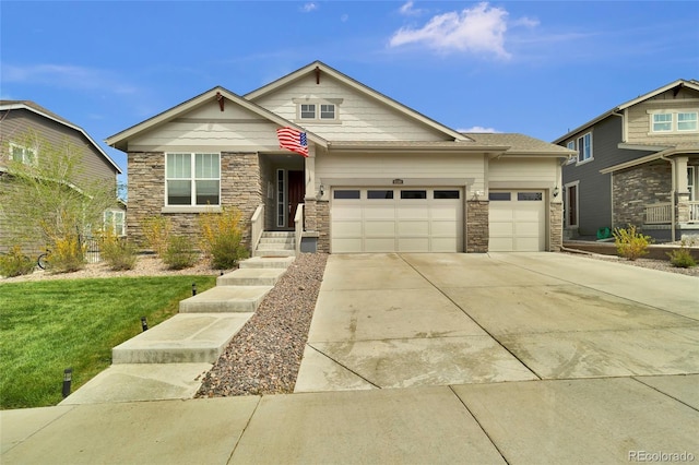 view of front of home featuring driveway, a front lawn, stone siding, and a garage