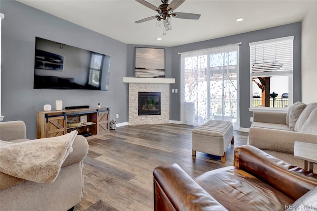 living area with recessed lighting, a ceiling fan, wood finished floors, and a fireplace