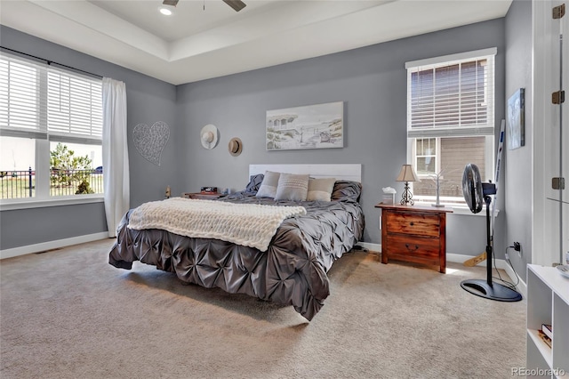 bedroom featuring baseboards, carpet flooring, a tray ceiling, and visible vents