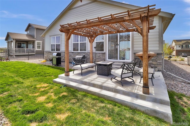 rear view of property featuring fence, a pergola, stone siding, an outdoor fire pit, and a yard