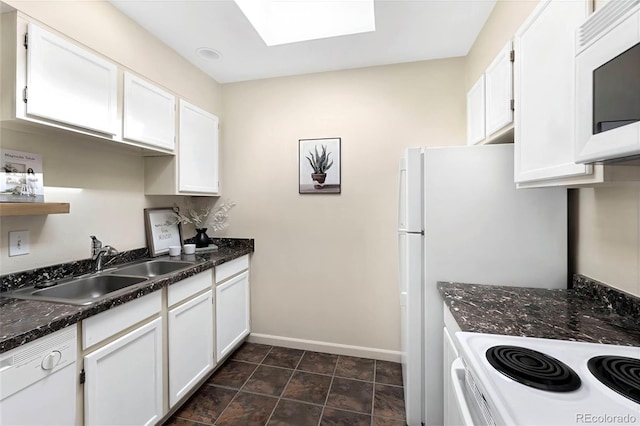 3050 W 32nd Ave Unit 202C, Denver, CO 80211 - kitchen with a sink, baseboards, a skylight, white appliances, and white cabinetry