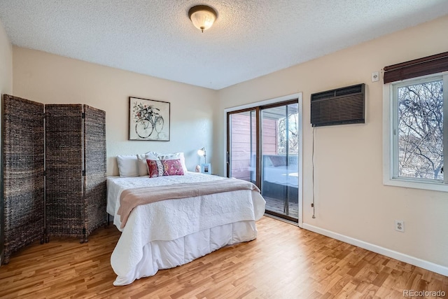 3050 W 32nd Ave Unit 202C, Denver, CO 80211 - bedroom with wood finished floors, access to exterior, a wall mounted air conditioner, a textured ceiling, and baseboards